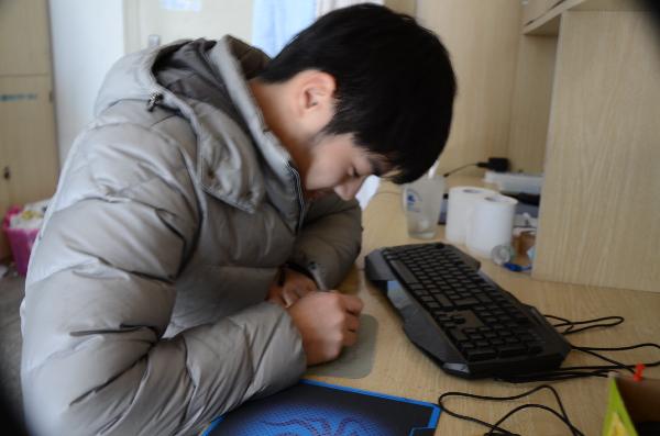 图一:大一男生在写对女生们的祝福卡片 图一:大一男生在写对女生们的祝福卡片